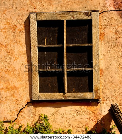 Closeup of a wood window frame with cracking stucco.