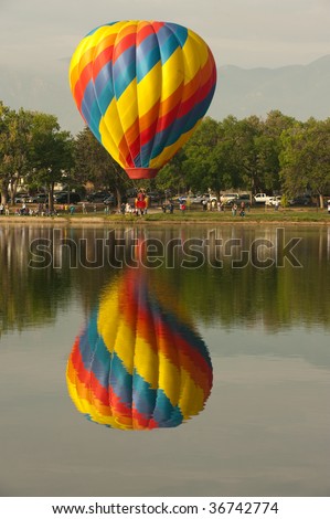 COLORADO SPRINGS - SEPTEMBER 6: A single hot air balloon prepares to dip their basket in the lake at Colorado Springs Hot Air Balloon Festival September 6, 2009 in Colorado Springs, Colorado.