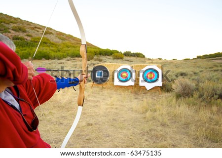 Archer prepares to shoot arrow at target.