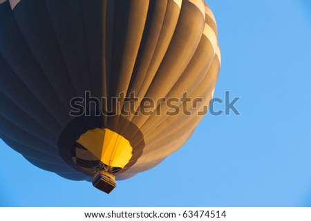 Hot air balloon in flight with the morning sun shinning on it.
