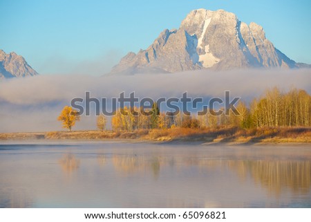 View from Oxbow Bend looking at the Grand Tetons with low lying ground fog.