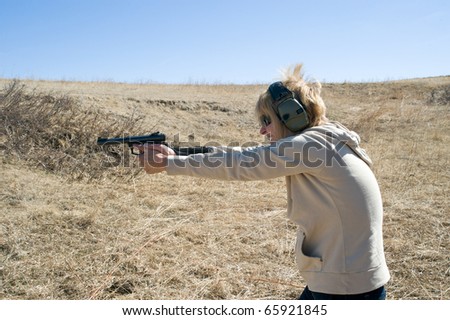 Closeup of a woman taking target practice at a gun range.