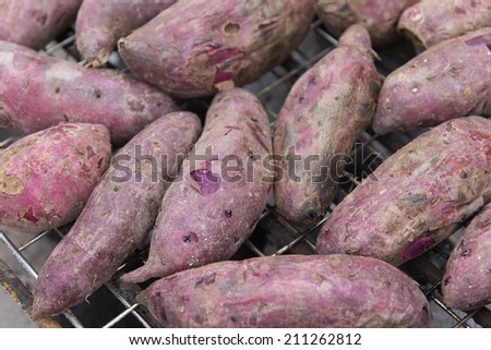 Grilled purple sweet potato on hot gridiron for sell.