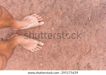 Closeup of feet muddy on the floor.