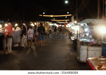 Blurred image of tourists walk in night market