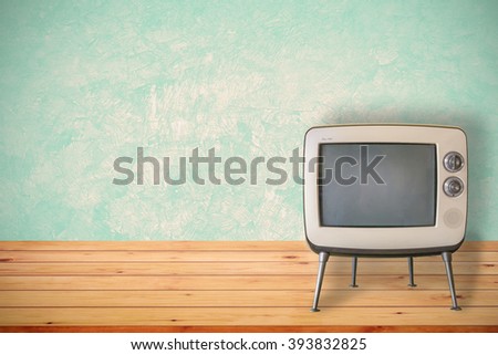 Old television on wood table. Vintage color tone style.
