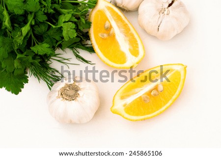 Flavorings for cooking meat. slices of lemon, garlic cloves and parsley on white background