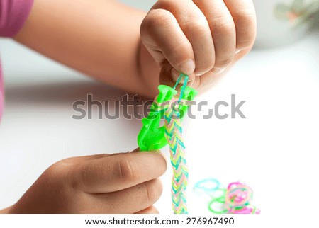 Young Girl make rubber band bracelet with a loom