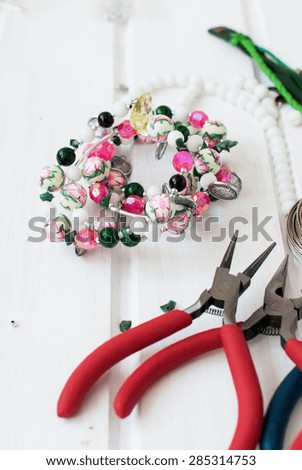 different beads made of glass and plastic, chains and tools for making jewelry