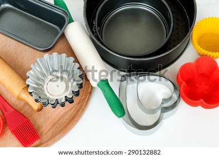 Cake pans and round metal bakeware, wooden rolling pin on a wooden background