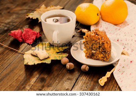 cup of black tea flavored with slices of spicy carrot cake with walnuts The Lake and spices, lemon, walnut kernels, cake on a plate selective focus, toned photo