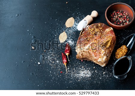 pork meat marinated in salt and spices on the board with grains of mustard, pepper, top view