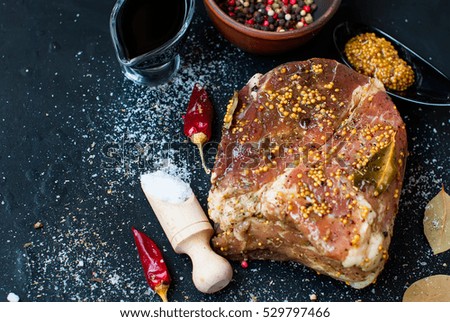 pork meat marinated in salt and spices on the board with grains of mustard, pepper, top view