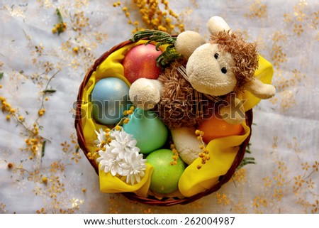 Easter lamb with colored pearly eggs in basket. Shallow depth of field