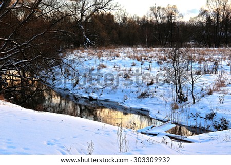 Winter sunset on rural river at twilight