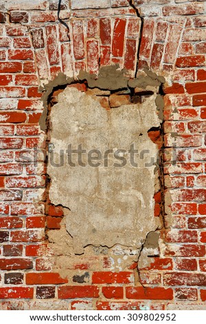 Wall of old orange shabby bricks with concreted window opening as background or texture. Vertical orientation