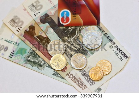 TULA, RUSSIA - October 23, 2014: Russian money - notes and coins, and plastic card payment on October 23, 2014 in Tula, Russia. Shallow depth of field. Focus on metal coins