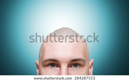 Bald man looks out from the bottom. Bald man on a blue gradient background