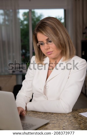 Business woman at home behind laptop