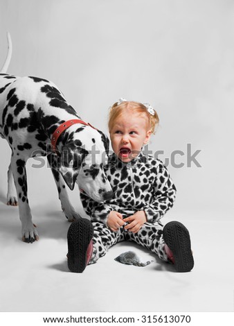 Girl dressed as Dalmatian afraid of mice, and next to her Dalmatian dog who looks at a mouse with interest