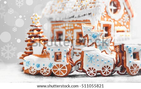 Christmas card. Assorted Christmas gingerbread cookies. Christmas gingerbread village, house, train, tree. Christmas New Year's background with snowflakes. Christmas food gingerbread house, train