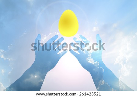 Golden egg in Hand on Blue sky and sunlight