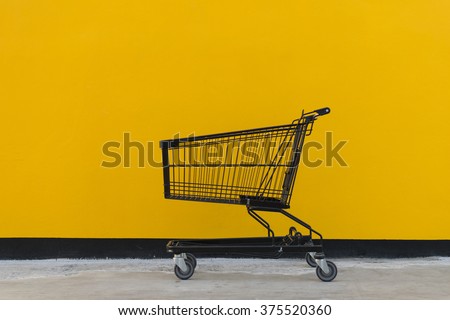 Minimalism style, Shopping cart black color and yellow wall at supermarket.