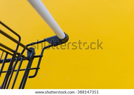 Minimalism style, Shopping cart black color and yellow wall at supermarket.