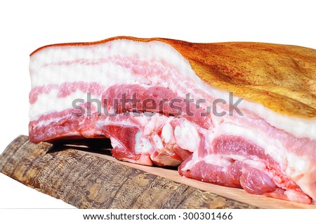 A piece of bacon in a cut on a wooden board isolated on white background. Focus in the center of the image.