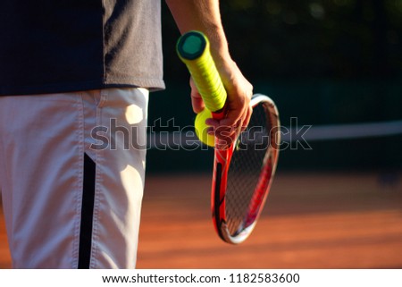 A tennis player prepares to serve a tennis ball during a match