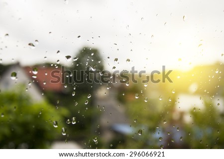 Window after rain! A small german city background. Water drops on a window glass after the rain. Sunshine light. It is Amazing view.