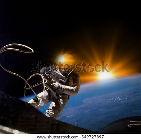 Astronaut on space mission with sun and earth background. Elements of this image furnished by NASA.