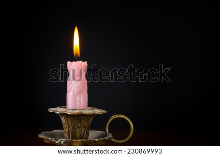 Christmas candle with flame on black background