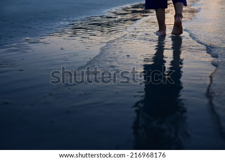 man feet on the beach at sunrise