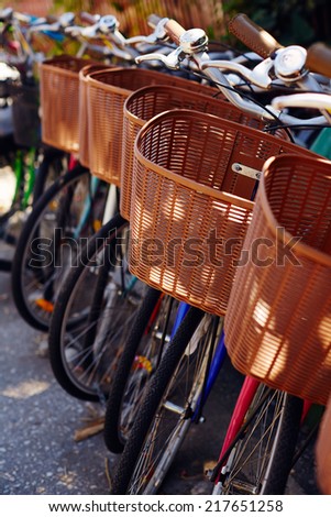 Parked bikes with wicker baskets for rent by tourists
