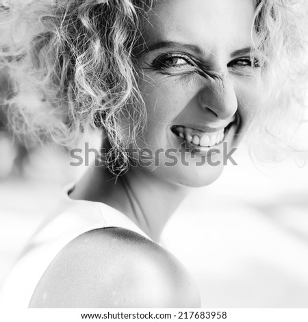 Young happy laughing girl on the street. Black and white portrait.