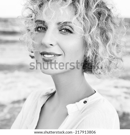 Young happy laughing girl on the beach. Black and white portrait.