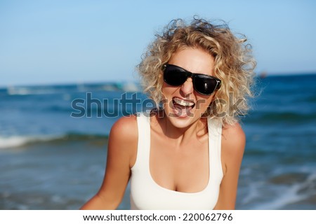 Young happy smiling crazy girl outdoor portrait. Background of the sea.