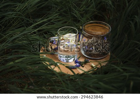 glass cup of tea and tea leaves on a grass