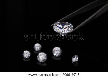 Diamond jewelry holding A round brilliant cut diamond held in tweezers