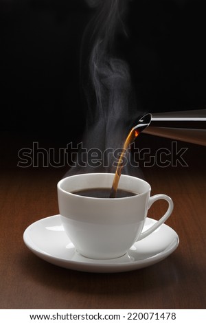 Cup of black coffee/Cup of black coffee with steam on the wooden table