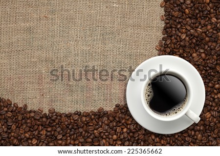 Cup of coffee on beans/Coffee beans and Coffee cup on a  jute background