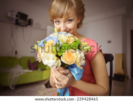 A young girl holding beautiful flowers. A caucasian model with blonde hair and blue eyes.