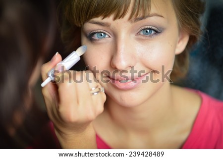 A teenager girl with cute face and blue eyes smiling While getting a make up.