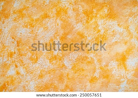 Orange painted wall, cracked, dirty with little sand specks