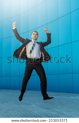 Exited happy business man in suit jumping and selebrating success