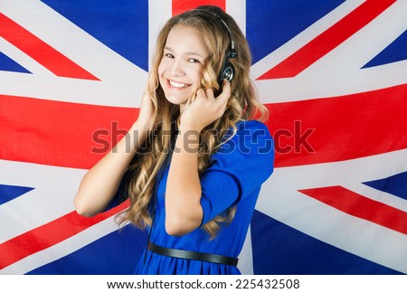 Learn English. Pretty school girl in headphones over british flag