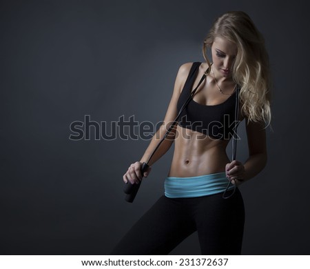 Female runner on beach with sports bra and shorts. Midsection