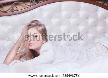 Good morning concept. Beautiful sexy seductive young woman in luxury bad in white lingerie looking at camera.