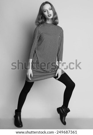 Fashion portrait of young beautiful female model  in casual dress and boots.